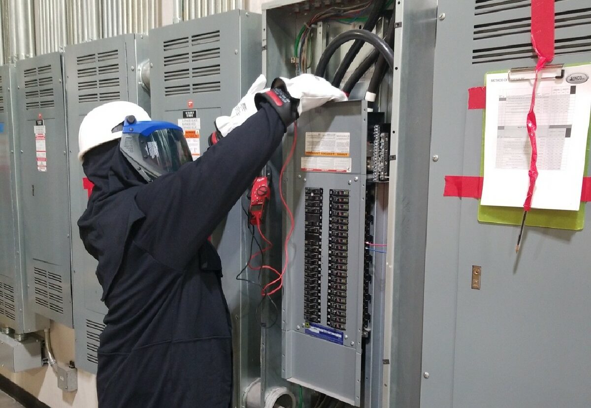 A Jenco electrical technician performs preventative maintenance on an electrical box